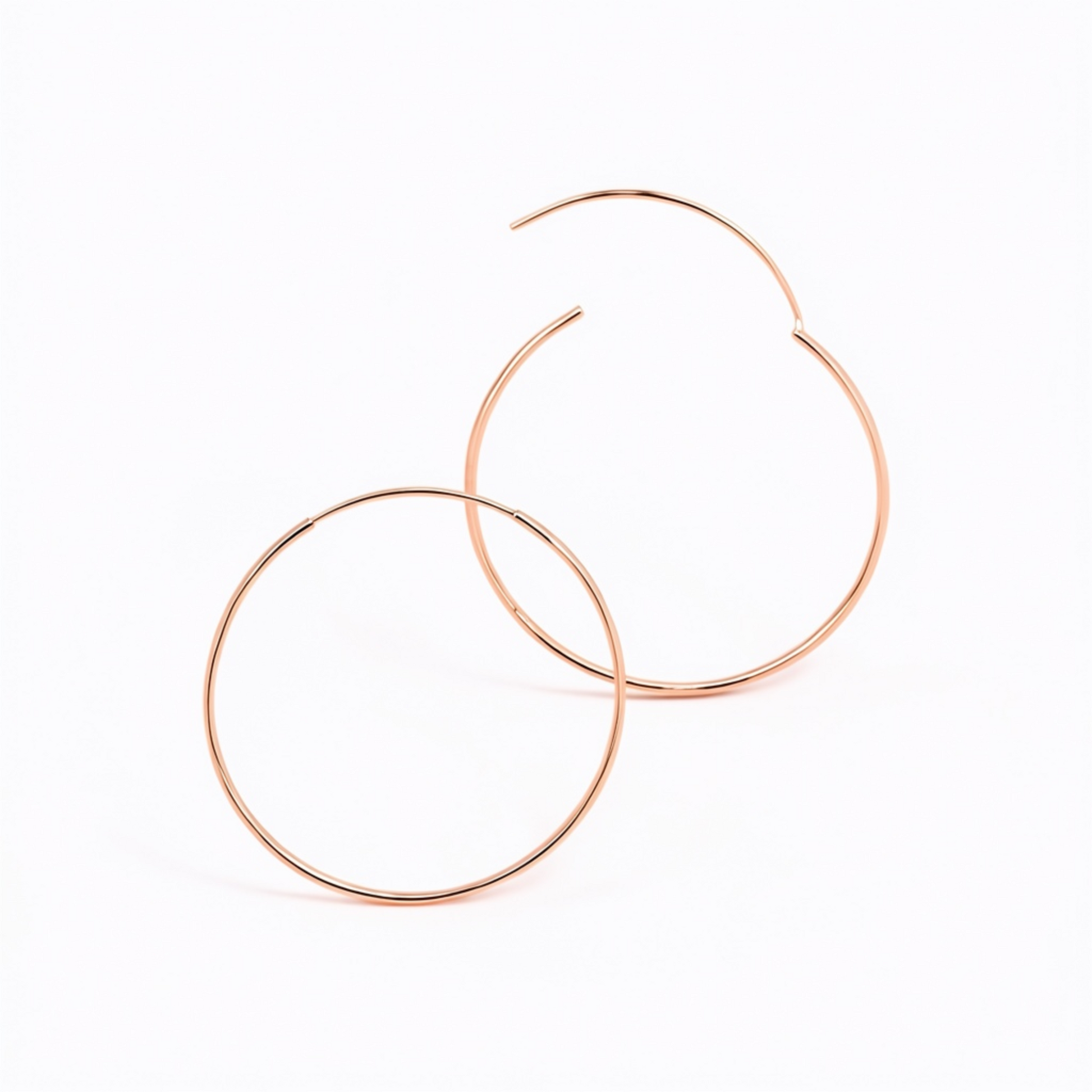 Detailed view of overlapping 50mm 925 sterling silver rose gold fine hoop earrings showing the open clasp closure on a white background 
