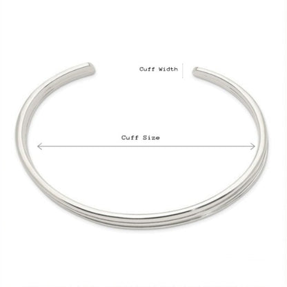 Silver bangle with labeled cuff width and size on a white background